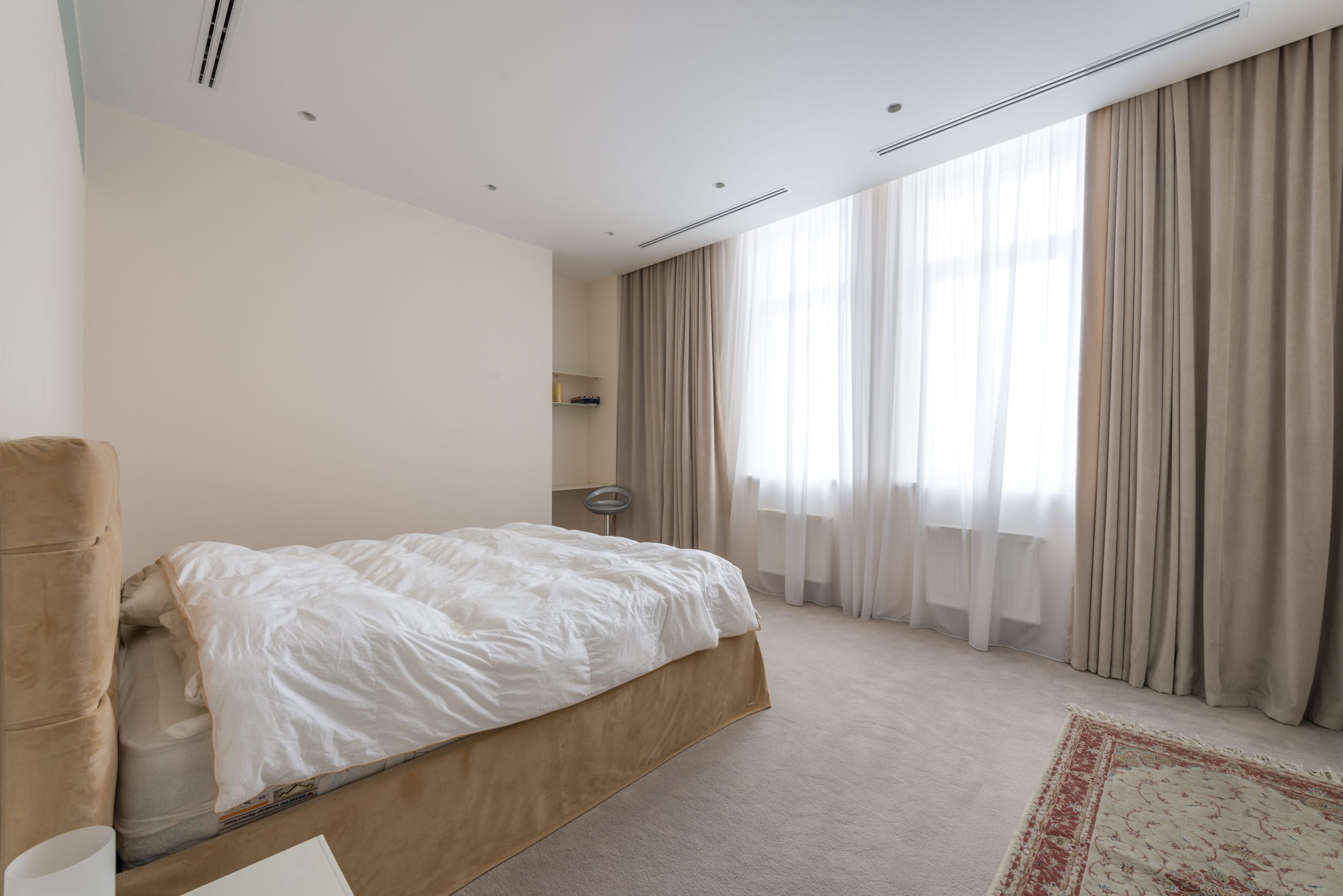 Cream wall-to-wall carpet in a bright Utah bedroom with sheer curtains