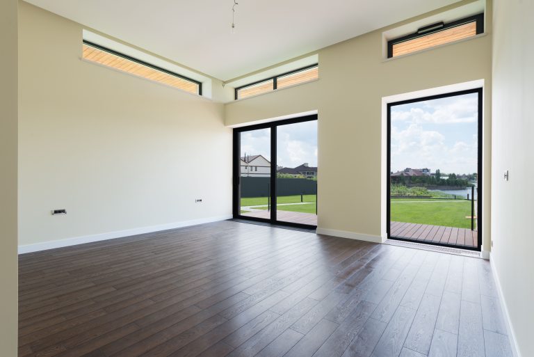 Dark wood-look laminate flooring in an empty Utah room with full-height windows