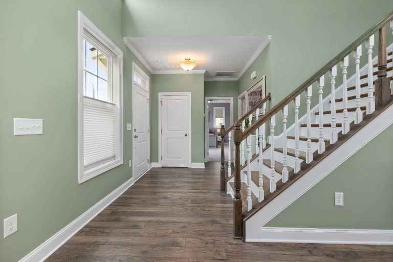 Wooden stair treads with white balusters above a wood entry floor in a Utah home