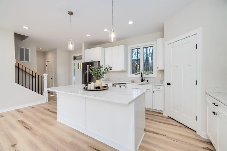 Light plank flooring in a white Utah kitchen with a central island