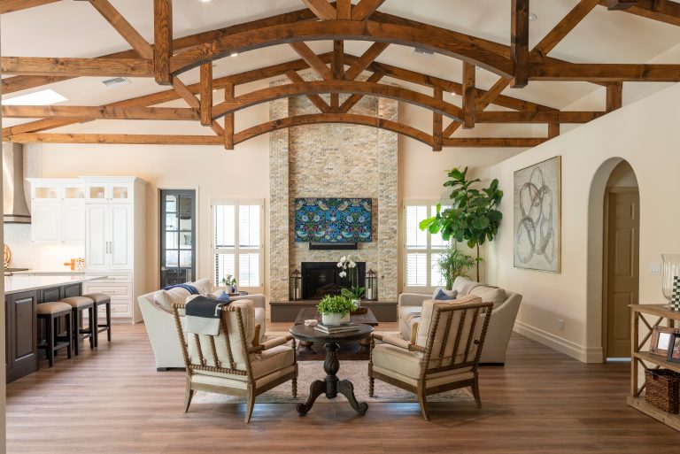 Wide-plank wood flooring in a Utah living room with exposed timber trusses and a stone fireplace
