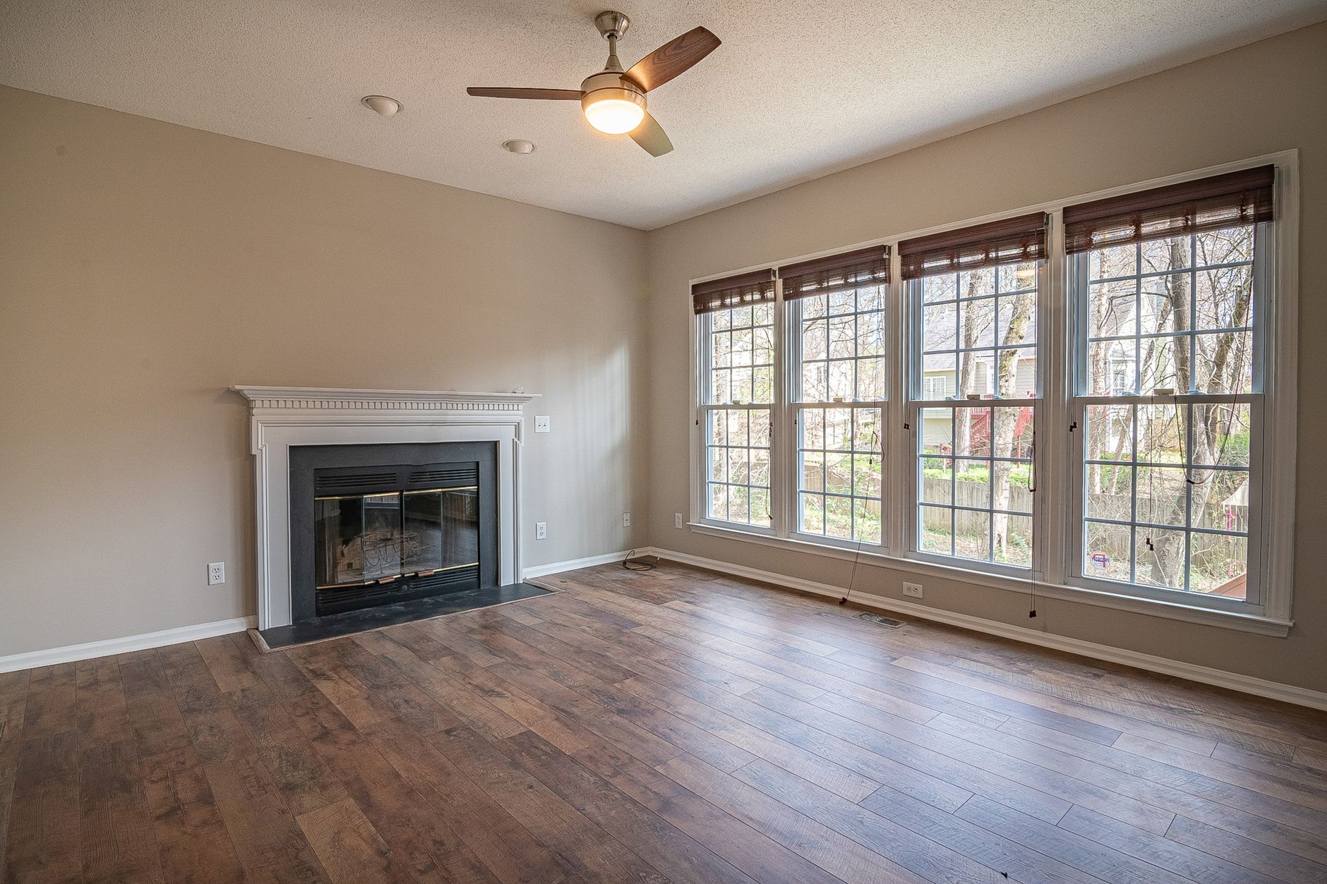 A bright and spacious modern living room interior with a fireplace and large windows